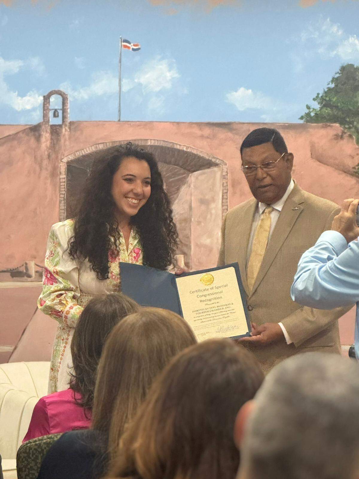 Eyvana Bengochea, asesora senior de la oficina de la congresista María Elvira Salazar, entrega a Pedro J. Díaz Ballester, presidente de la Cámara Dominicana Internacional de Negocios y Turismo, un certificado de reconocimiento congresional especial, por sus 45 años promocionando las relaciones de comercio, negocios, turismo, inversiones, y desarrollo entre Estados Unidos y la República Dominicana.