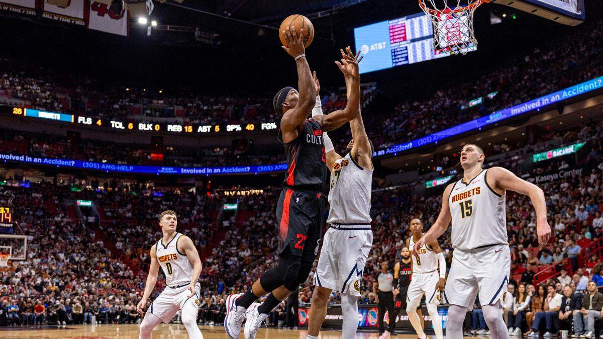 El jugador del Heat Jimmy Butler (22) tira al aro ante la marca de Jamal Murray, de los Nuggets de Denver, en el partido celebrado el 13 de marzo de 2024 en Miami.