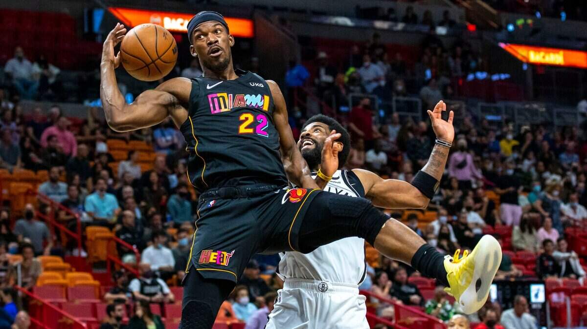 El jugador del Heat forward Jimmy Butler (izq.) realiza una jugada ante la marca de Kyrie Irving, de los Nets de Brooklyn, en el partido celebrado el 12 de febrero de 2022 en Miami.