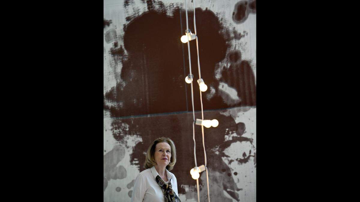 Rosa de la Cruz mira una obra de Félix Gonzalez-Torres mientras se encuentra frente a una obra de Christopher Wool en la Colección de la Cruz en el Design District.