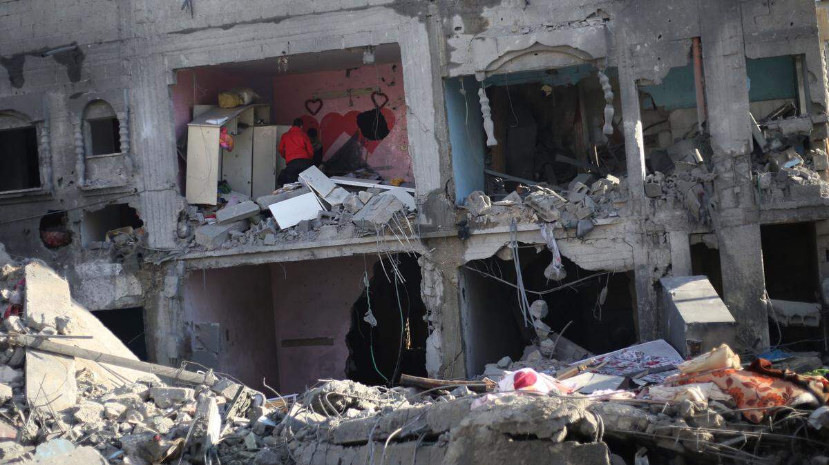 Palestinos revisan los escombros de los edificios dañados por los ataques aéreos israelíes en la ciudad de Rafah, en el sur de la Franja de Gaza, el 12 de febrero de 2024.