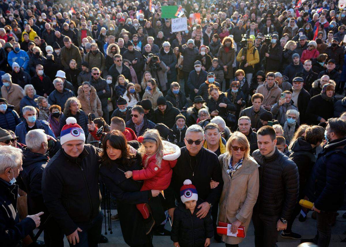 El padre de Novak Djokovic, Srdjan, al centro, su madre Dijana, segunda a la derecha, y el hermano Djordje, a la derecha, durante una protesta en Belgrado, Serbia, el viernes 7 de enero de 2022.