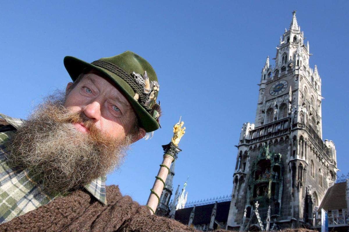 Un hombre vestido con un traje típico de la región de Baviera en la plaza Marienplatz de Múnich, Alemania.