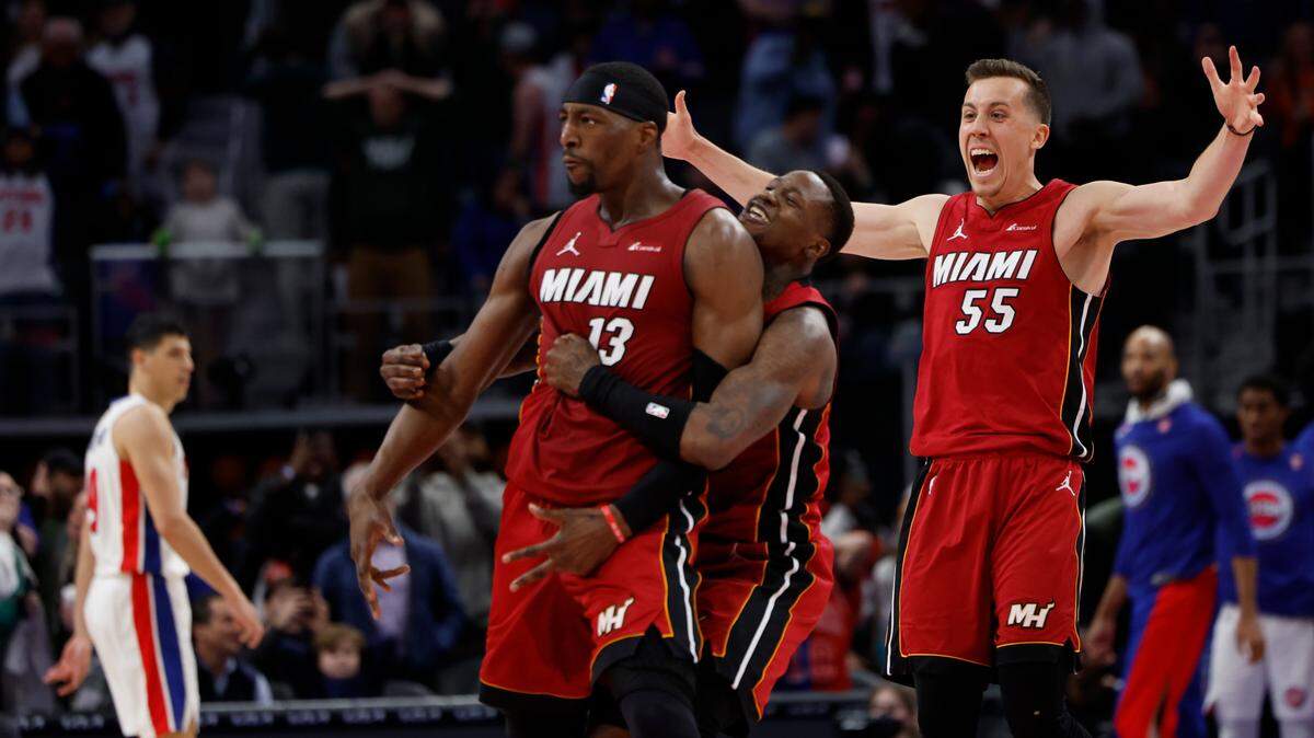 El jugador del Heat de Miami Bam Adebayo (13) celebra con Terry Rozier (2) y Duncan Robinson tras encestar el triple que le dio la victoria a su equipo en el segundo final del partido ante los Pistons, celebrado el 17 de marzo de 2024 en Detroit.