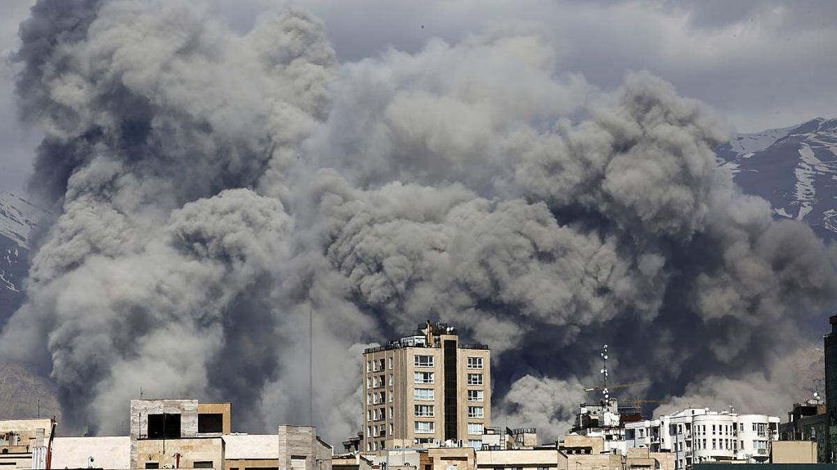 Una columna de humo se levanta detrás del edificio de la Radiodifusión de la República Islámica de Irán, en Teherán, el 1 de marzo de 2026.
