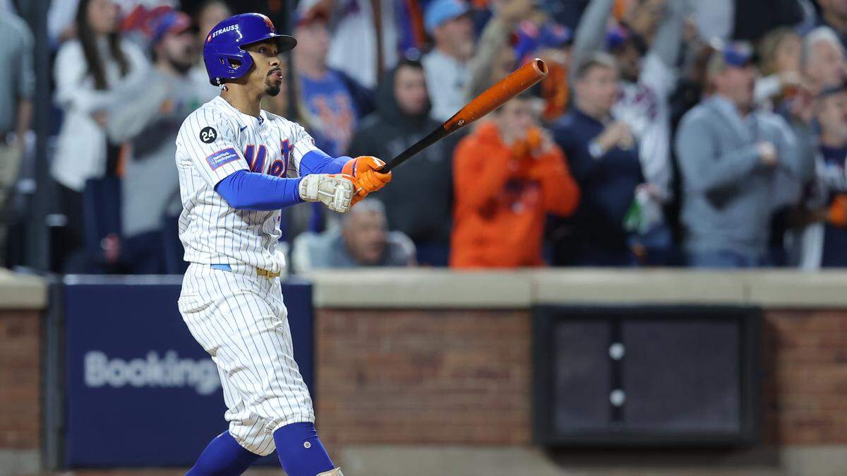 El torpedero de los Mets de Nueva York Francisco Lindor batea un jonrón con las bases llenas contra los Filis de Filadelfia, en el partido de postemporada celebrado el 9 de octubre de 2024 en Nueva York.