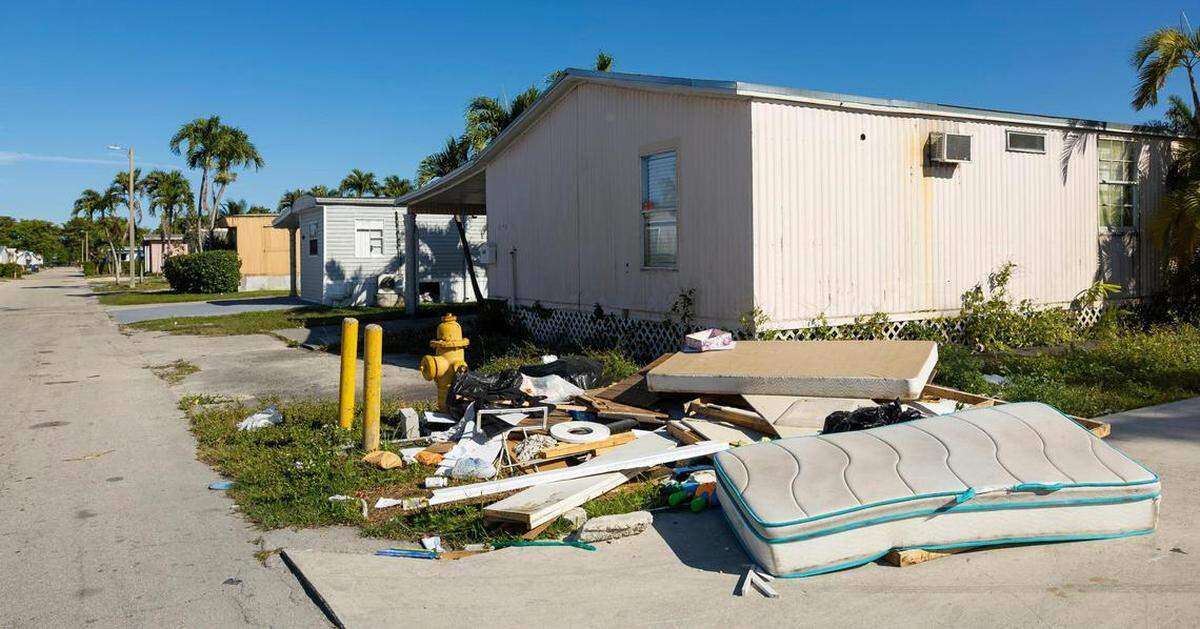 Basura y pertenencias de los vecinos se ven apiladas frente a una casa en la 3rd. terrace del NW, en Sweetwater, Florida, en el parque de casas móviles Li’l Abner, el viernes 7 de marzo de 2025.