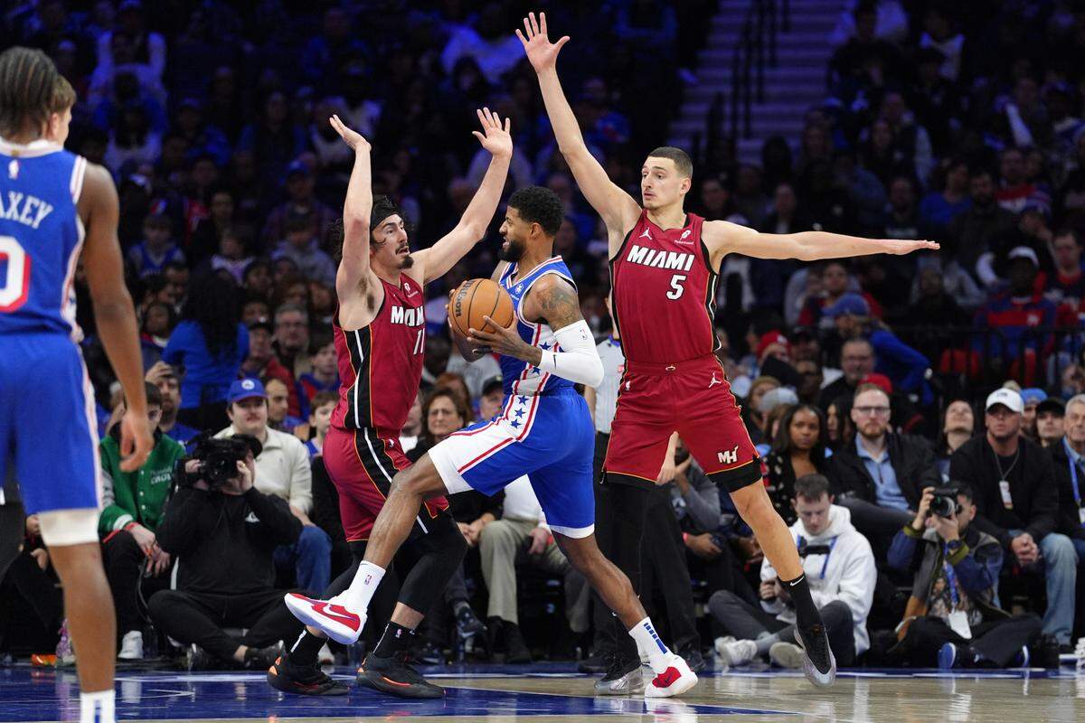 El jugador de los 76ers Paul George (centro) entra al aro ante la defensa de Jaime Jáquez Jr (izq.) y Nikola Jovic, del Heat de Miami, en el partido celebrado el 5 de febrero de 2025 en el Wells Fargo Center de Filadelfia.