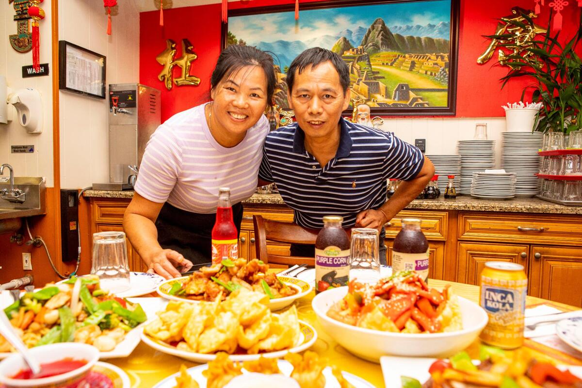 Jingquan Du y su esposa Juana, dueños del restaurante chino peruano Chifa Du Kang, frente a algunos de los platos del menú, el 17 de mayo.