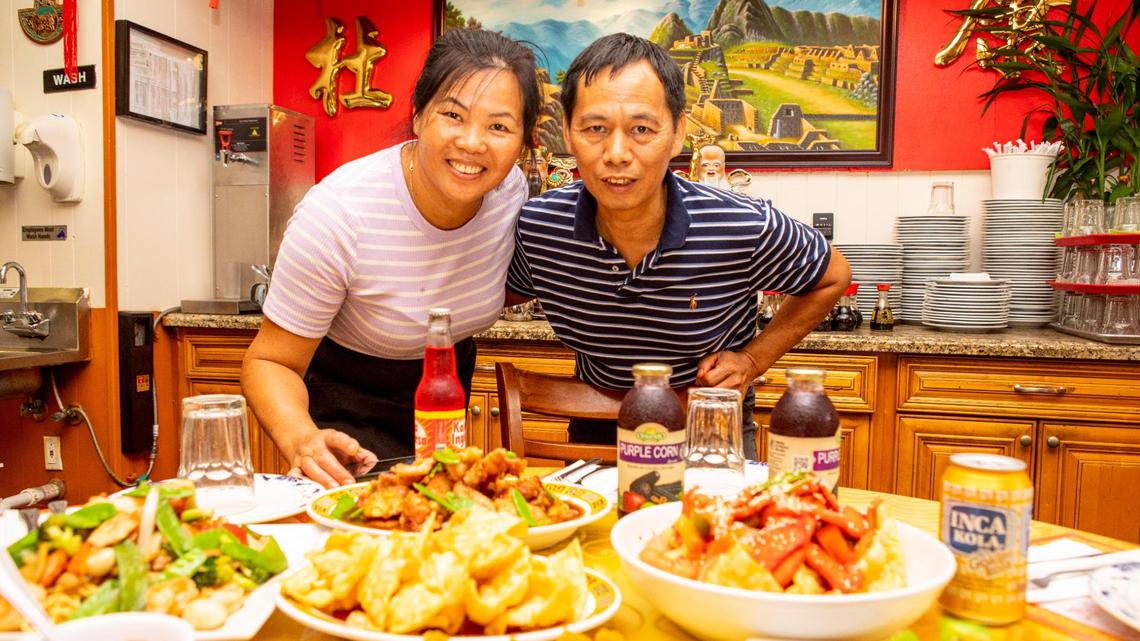 Chef/owners of Chinese/Peruvian restaurant Chifa Du Kang, Jingquan Du and his wife Juana Du, stand behind a smorgasbord of dishes from their menu, at their restaurant, in Miami, Florida, on Monday, May 17, 2021.