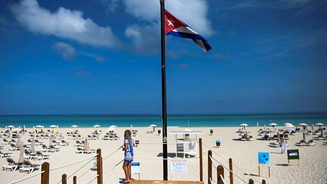 Foto de archivo que muestra una niña parada cerca de una bandera cubana en una playa en el Hotel Meliá International Varadero en Varadero, Cuba, el 3 de septiembre de 2021.  
