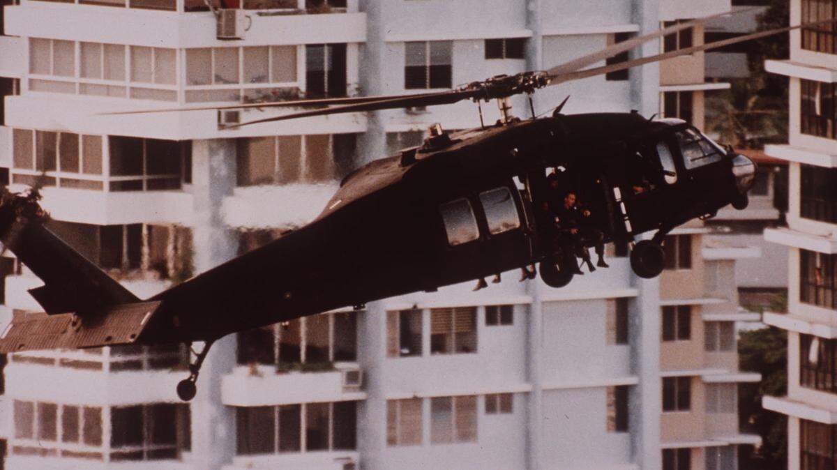 Días después de la invasión de los Estados Unidos, un helicóptero del ejército transporta refuerzos a la embajada del Vaticano en la ciudad de Panamá. El general Manuel Noriega se refugió en la embajada luego de que el avance de las tropas estadounidenses lo obligara a esconderse.