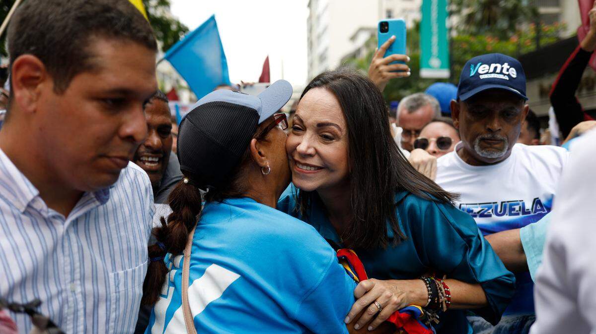 La dirigente opositora venezolana María Corina Machado saluda a una seguidora antes de llegar a la Plaza Altamira para anunciar su candidatura presidencial, el 23 de junio de 2023, en Caracas.