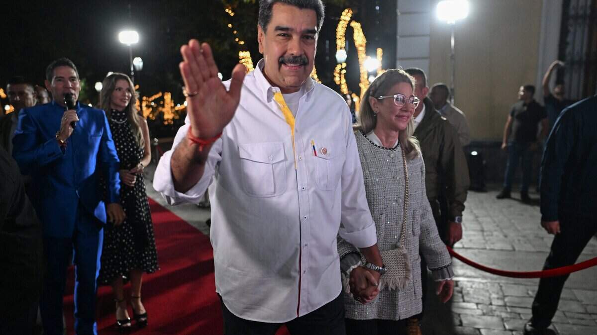 Venezuela's President Nicolas Maduro and his wife Cilia Flores wave to supporters as they arrive for the screening of a biographical series at the National Theatre of Venezuela in Caracas on November 22, 2025. (Photo by Juan BARRETO / AFP via Getty Images)