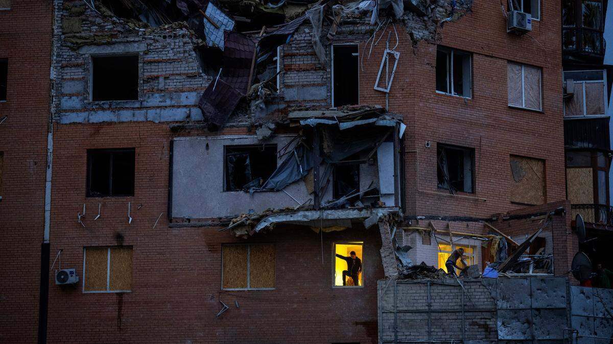 Personas revisan los daños en sus apartamentos luego de un ataque ruso con misiles, el domingo 23 de octubre de 2022, en Mykolaiv. 