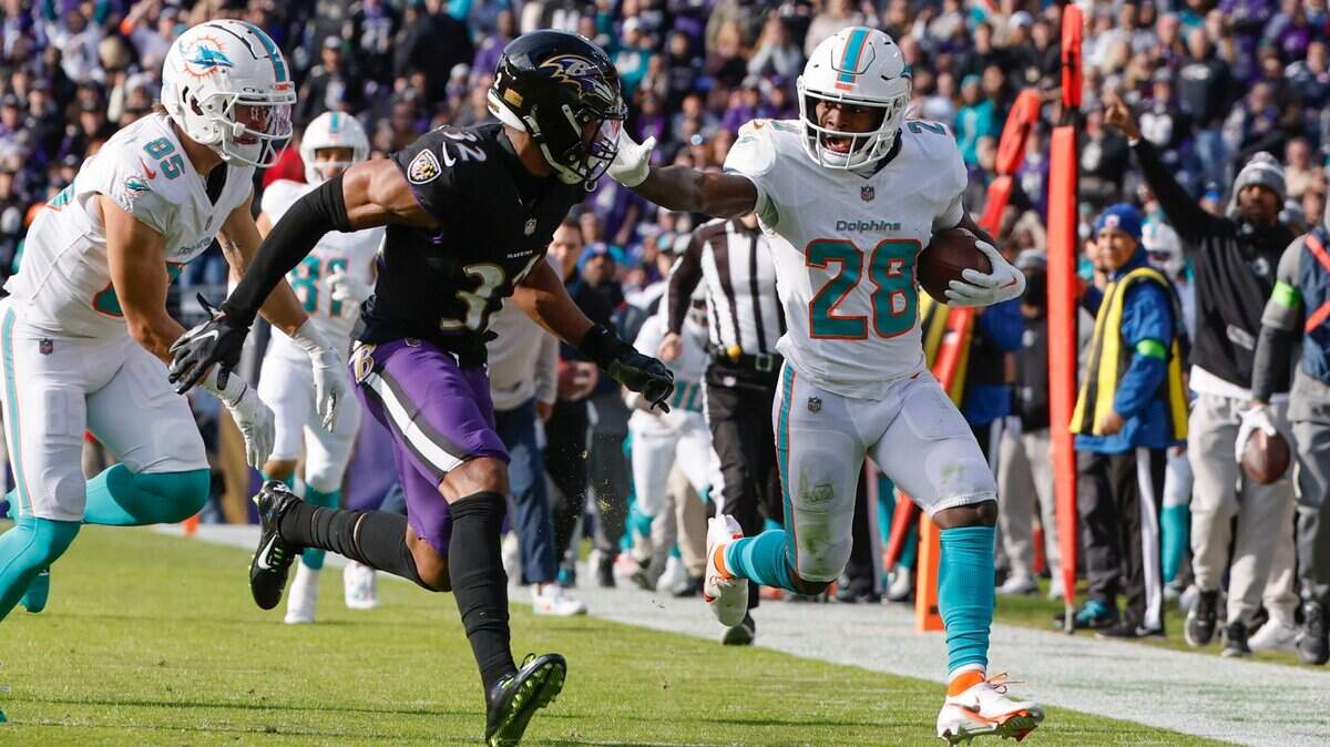El running back de los Dolphins de Miami De’Von Achane (28) corre con el ovoide ante la marca del safety de los Ravens Marcus Williams (centro) en el partido celebrado el 31 de diciembre de 2023 en Baltimore.