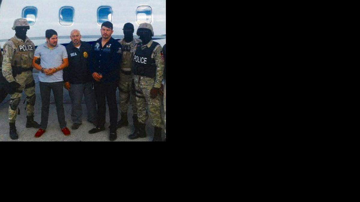 Efraín A. Campo, 2º de la izquierda y Francisco Flores, el 4º desde la izquierda, esposados después del arresto en Haití.