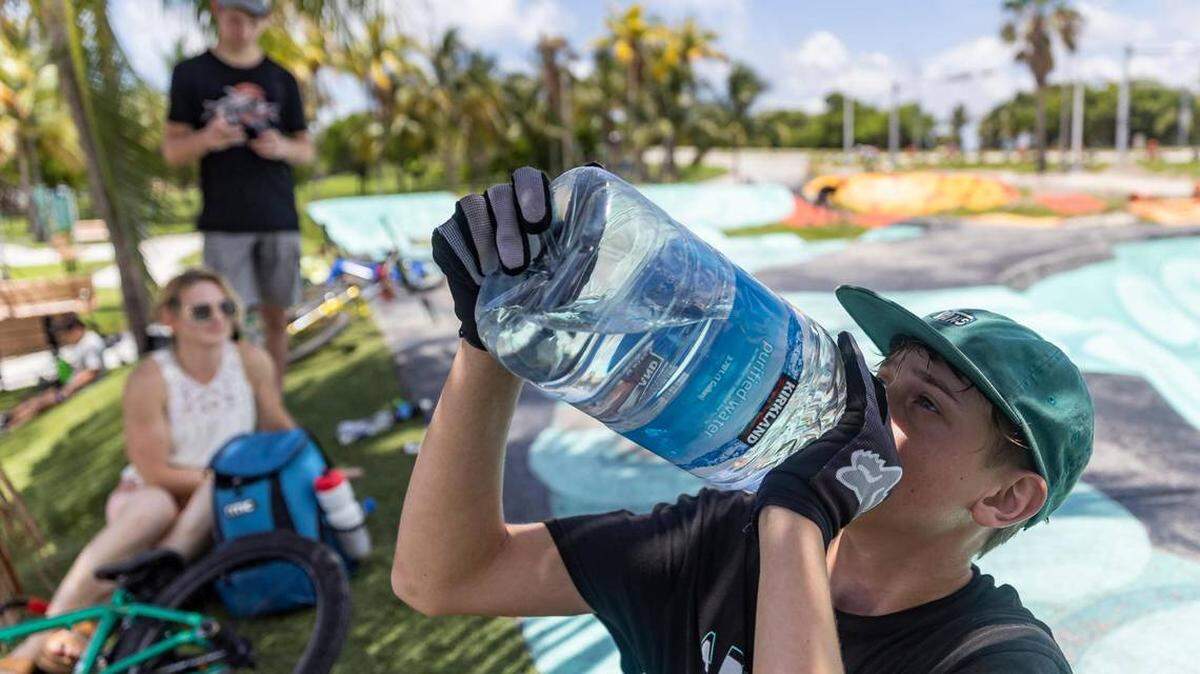 Aaron McElwain, de 13 años, bebe un poco de agua, después de montar su patineta en el Haulover Skateboard Park, el miércoles, 14 de junio de 2023, en Miami Beach.