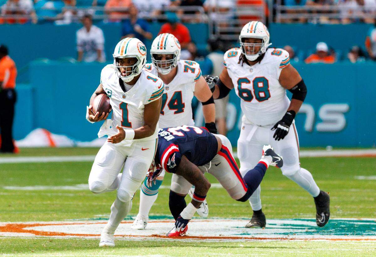 El quarterback de los Dolphins Tua Tagovailoa (1) corre con el ovoide en el partido contra los Patriots de New England, celebrado el 29 de octubre de 2023 en el Hard Rock Stadium en Miami Gardens, Florida.