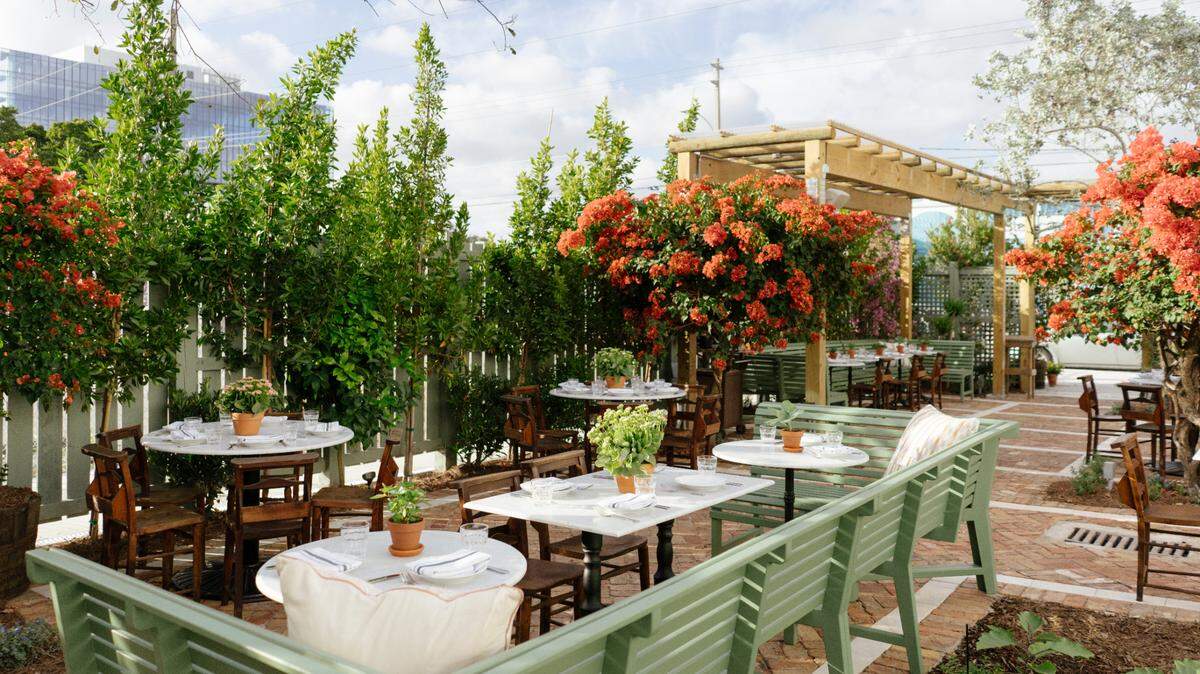 El jardín exterior y el comedor del nuevo restaurante italiano Rosemary’s en Wynwood.