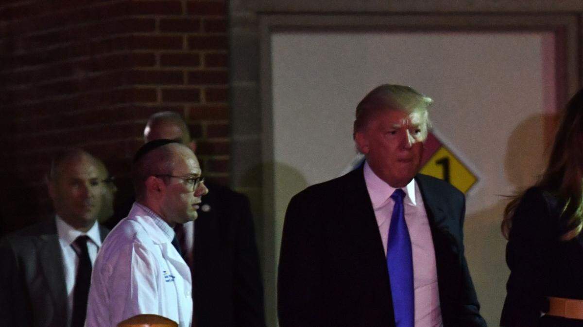 El Dr. Ira Rabin (I en chaqueta blanca) acompaña al Presidente de los Estados Unidos Donald Trump y a la Primera Dama Melania Trump del Centro Hospitalario MedStar, en Washington, el 14 de junio de 2017, después de visitar al congresista republicano Steve Scalise.