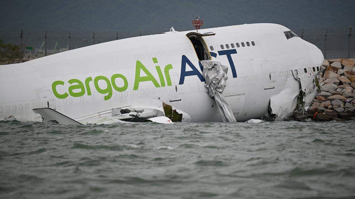 An ACT Airlines Boeing 747-400 cargo aircraft, wet leased by Emirates SkyCargo, is seen in the water after veering off the runway during landing on the north runway of Hong Kong's international airport on October 20, 2025, and skidded into the sea, killing two. A cargo plane veered off a runway October 20 during landing in Hong Kong, hit a security patrol car and then skidded into the sea, leaving two men in the vehicle dead, authorities said. (Photo by Peter PARKS / AFP) (Photo by PETER PARKS/AFP via Getty Images)