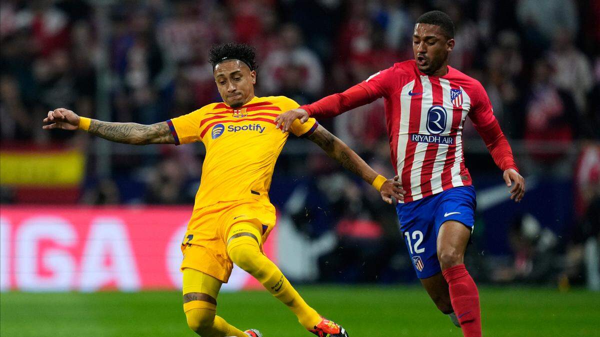 El jugador de Barcelona Raphinha (izq.) conduce la pelota ante la marca de Samuel Lino, del Atlético de Madrid, en el partido de la liga española celebrado el 17 de marzo de 2024 en Madrid.