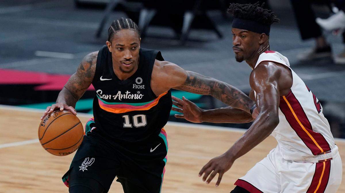 El jugador de los Spurs DeMar DeRozan (izq.) conduce la pelota ante la marca de Jimmy Butler, del Heat de Miami, en el partido celebrado el 21 de abril de 2021 en San Antonio.