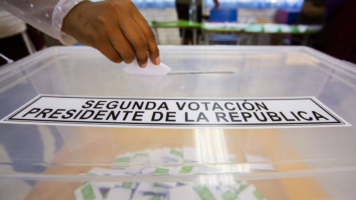 A person casts her vote during the presidential runoff election at Jose Abelardo High School polling station in Arica, near the Chile-Peru border on December 14, 2025. Chileans head to the polls for a presidential runoff between Jeannette Jara, a communist backed by a broad left coalition, and Jose Antonio Kast, a devout far-right politico promising a hard line on security and migration. (Photo by Patricio BANDA / AFP via Getty Images)