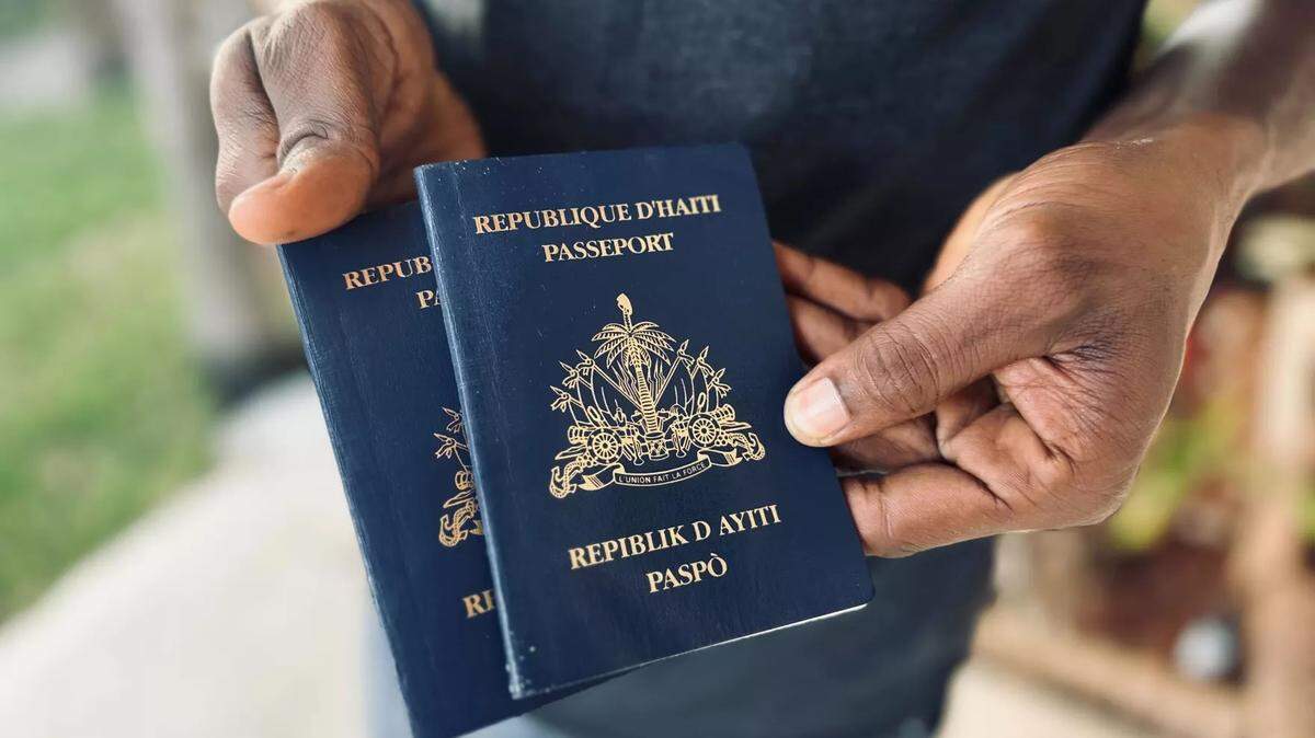 Un inmigrante haitiano que llegó recientemente con su novia al sur de Florida a través del programa de libertad condicional de Biden sostiene sus pasaportes. Pidió no ser identificado.