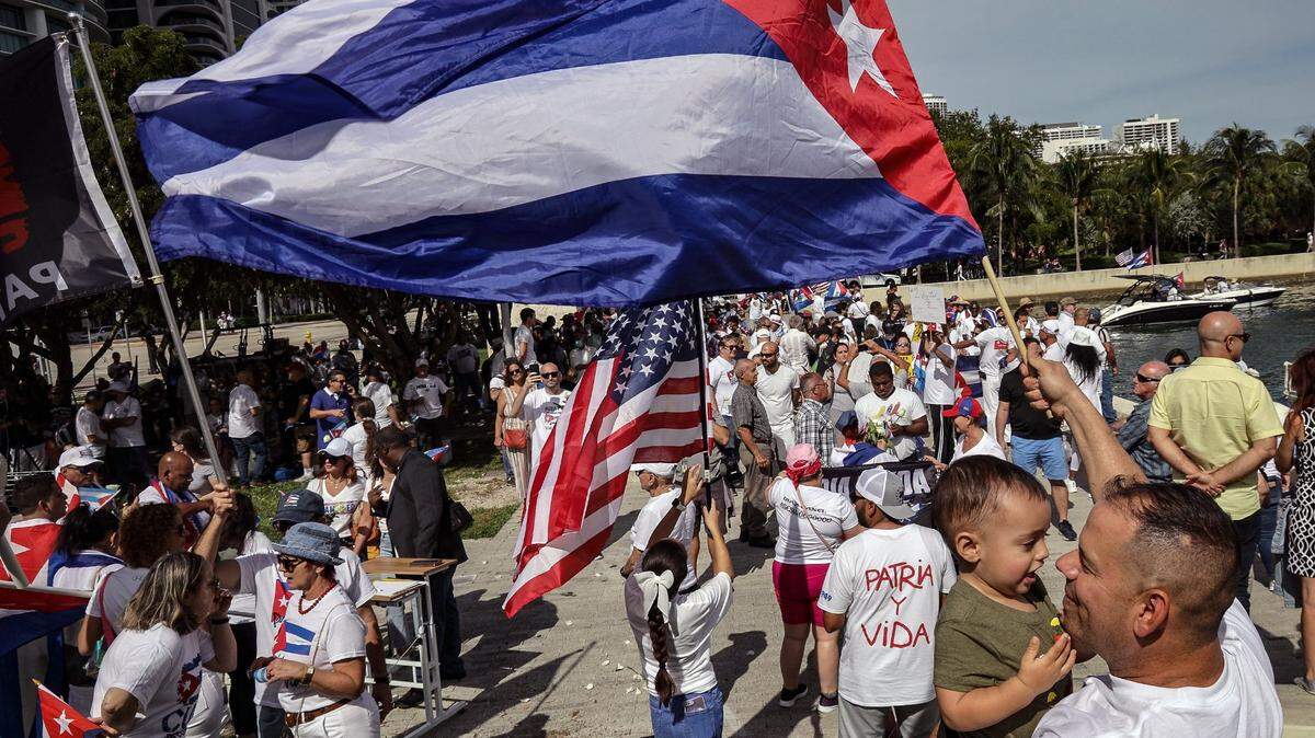 Yassel Pérez, derecha, sostiene a su hijo de 18 meses, izquierda, mientras asiste a una manifestación para mostrar solidaridad con el pueblo cubano en Miami.