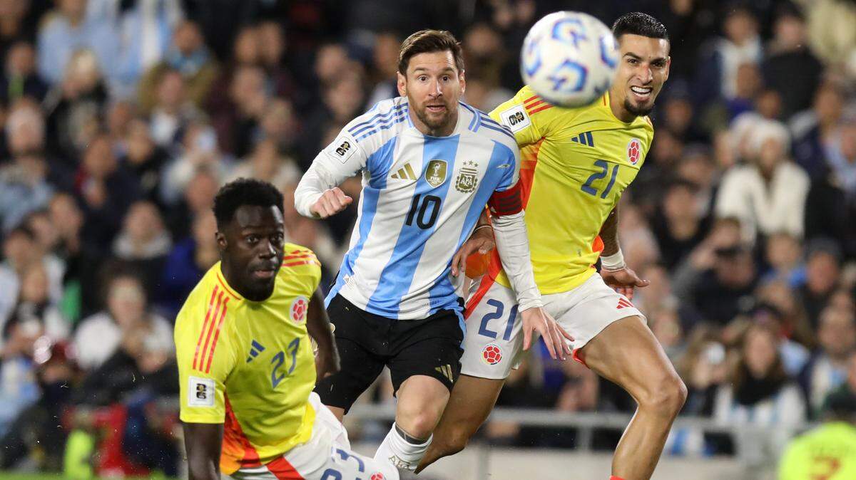 El delantero de Argentina Lionel Messi (centro) trata de evadir la marca de Davinson Sánchez (izq. y Daniel Muñoz, de Colombia, durante el partido de fútbol clasificatorio a la Copa Mundial, celebrado el  10 de junio de 2025 en Buenos Aires. 