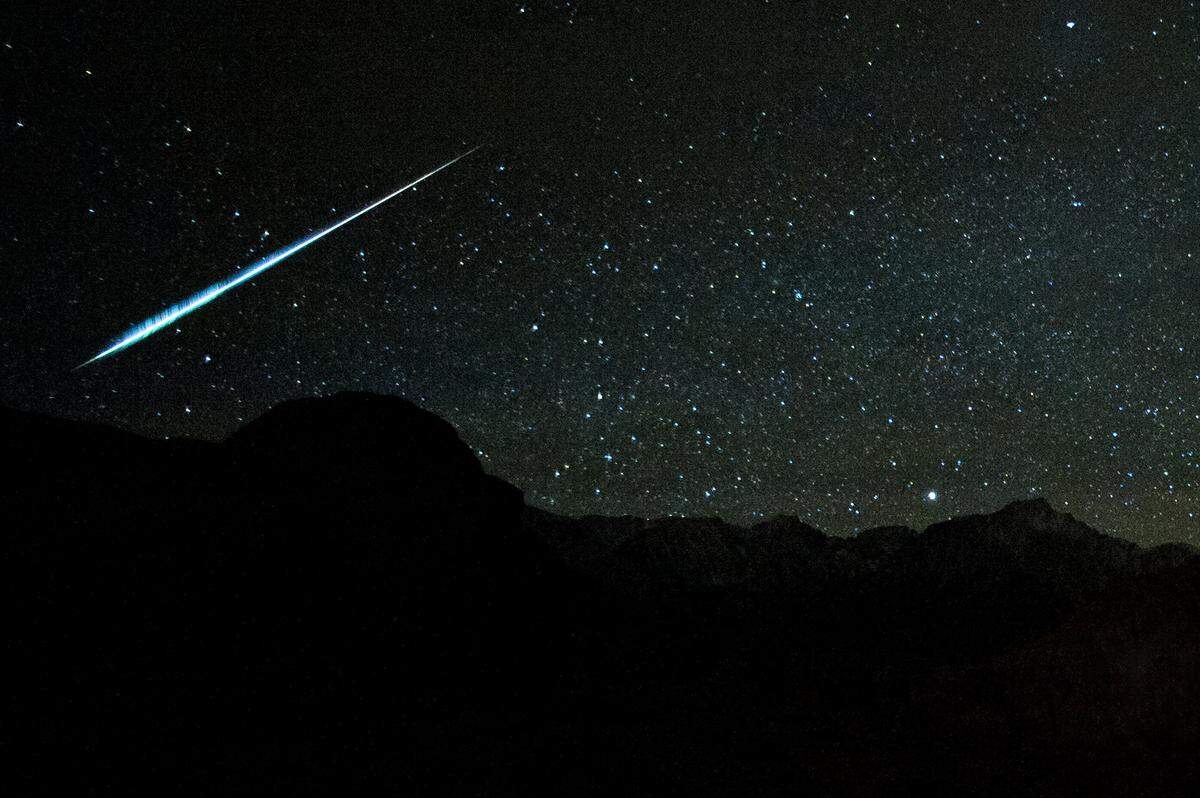 Foto ilustrativa. Un brillante meteoro Gemínida cruza los cielos oscuros en las Montañas de Sierra Nevada, California. ARCHIVO