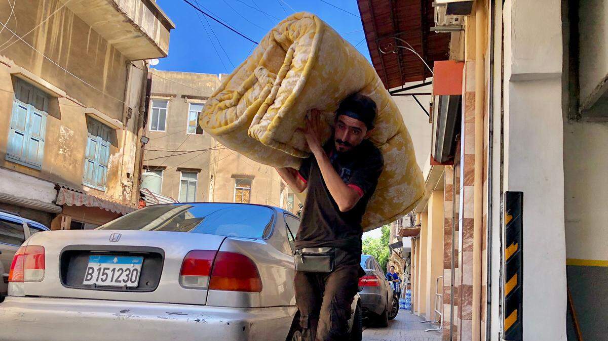 Un hombre carga una colchoneta el lunes 23 de septiembre de 2024 en una calle de Beirut, capital del Líbano, en donde se espera que lleguen miles de personas desplazadas por los bombardeos israelíes en contra de Hezbolá en el sur del país.