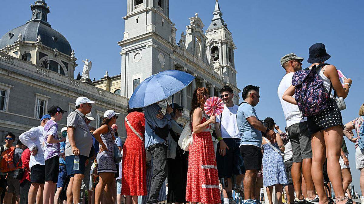 Foto de archivo de turistas en fila para entrar en el Palacio Real durante una ola de calor en Madrid el 5 de agosto de 2025.       