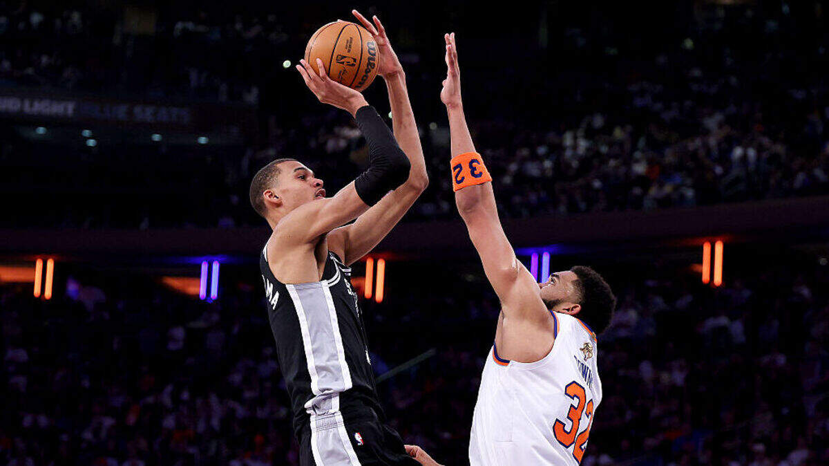 El astro de los Spurs Victor Wembanyama tira al aro ante la marca de Karl-Anthony Towns, de los Knicks, en el tercer partido de las Finales de la NBA, efectuado el 8 de junio de 2026 en Nueva York.