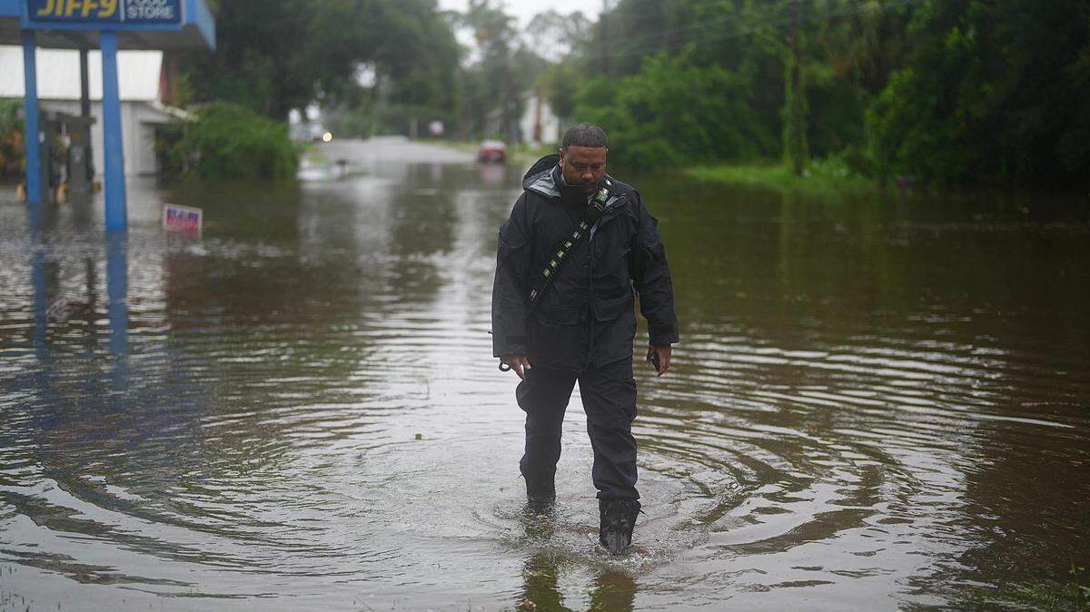Un integrante del equipo de búsqueda y rescate urbano (USAR) de Florida (FL-TF1) del Departamento de Bomberos de Miami-Dade (MDFR) inspecciona un sitio inundado en el norte de Florida, tras el paso del huracán Debby.