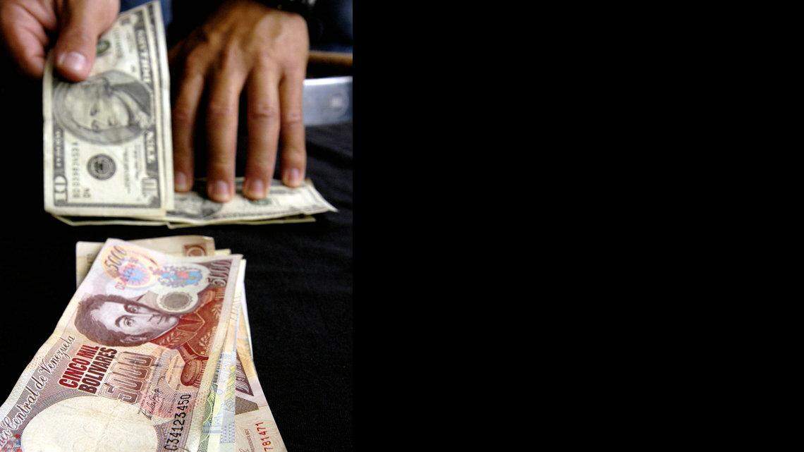 UN CAMBISTA del mercado negro vende dólares a cambio de bolívares en Caracas.