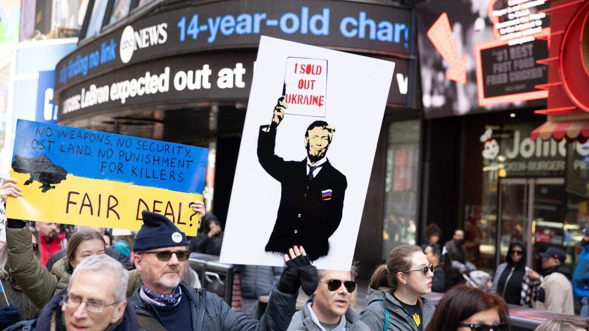Cientos de personas se congregan para manifestar su solidaridad con Ucrania y su derecho a ser independiente, en Times Square, Nueva York, el 9 de marzo de 2025. Una manifestante muestra un carte. que dice “Trump vendió a Ucrania”.