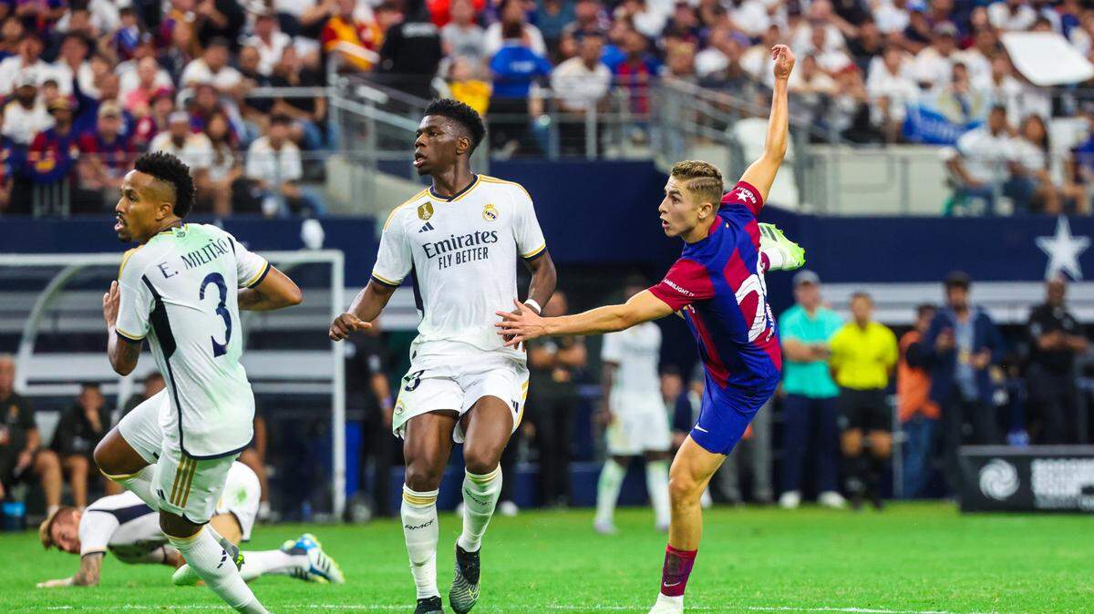 El jugador de Barcelona Fermín López Martín anota un gol frente a la marca de Aurelien Tchouameni (centro) y Eder Militao, del Real Madrid, en el partido celebrado el 29 de julio de 2023 en Arlington, Texas.