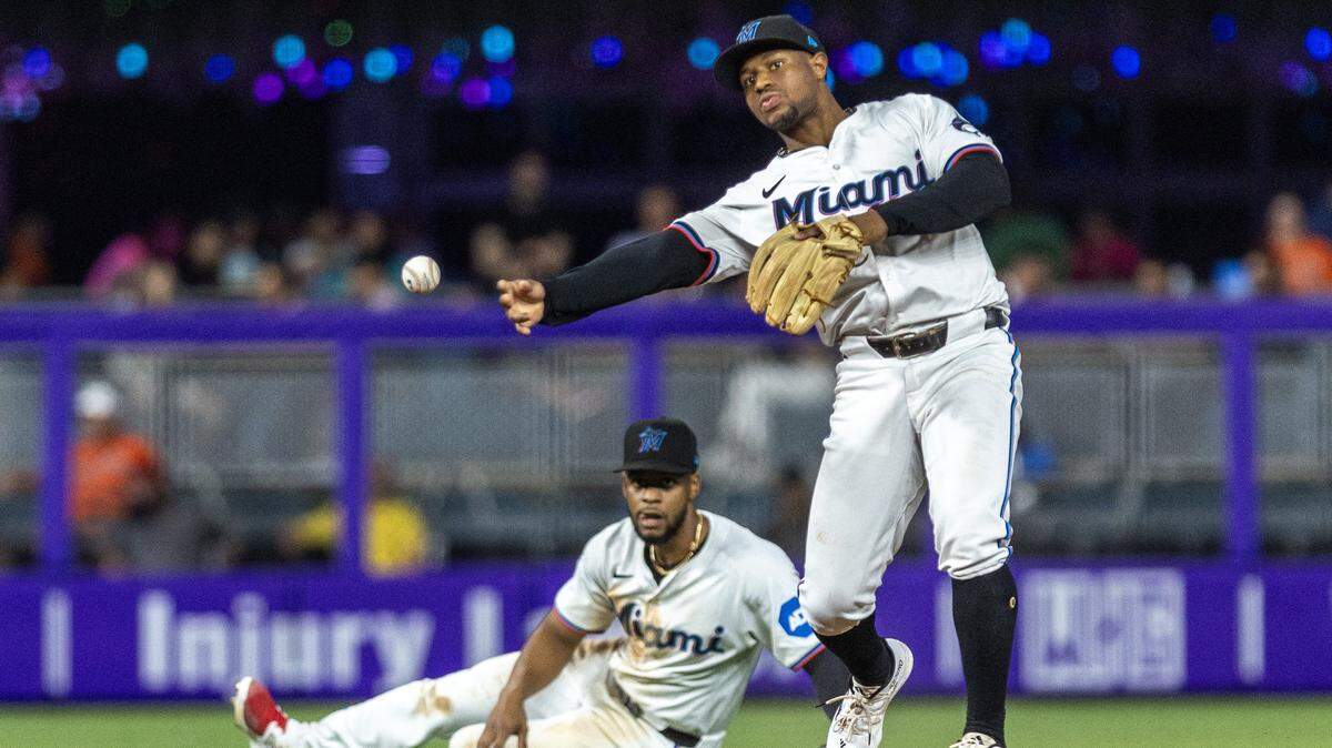Xavier Edwards (der.) tira a primera base mientras Otto López lo mira en una jugada en el octavo inning del partido ante los Orioles de Baltimore, celebrado el 23 de julio de 2024 en Miami.