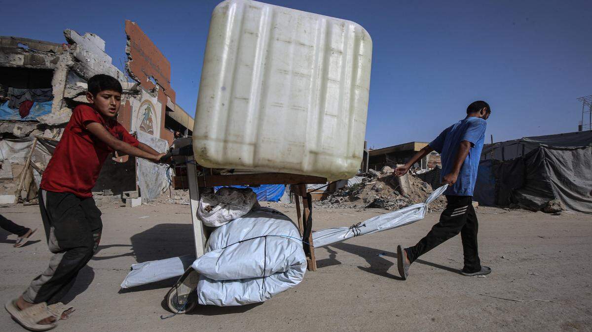 Residentes palestinos huyen hacia zonas que consideran más seguras, llevando sus pertenencias, tras los fuertes ataques israelíes en las zonas de Beit Lahia y Jabalia, en el norte de Gaza, el lunes 19 de mayo de 2025.