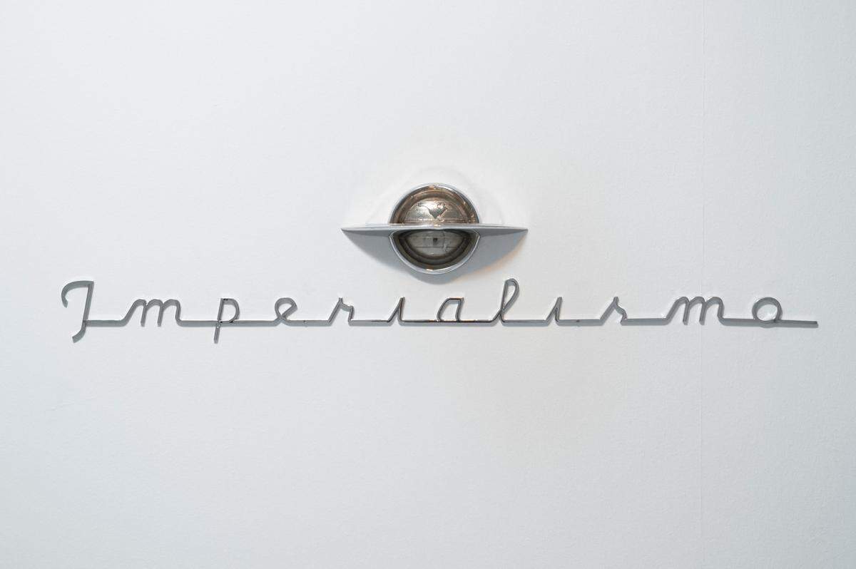 ‘Imperialismo’, 2018, de la serie ‘Emblemas’. Frases fundidas en letras Art Decó son contrapuestas a emblemas inspirados en marcas estadounidenses de coches.