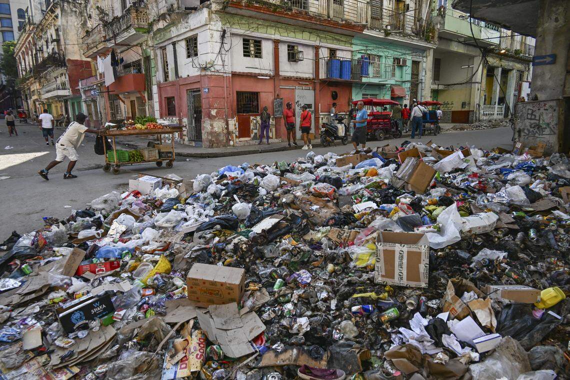 Locals walk past garbage piled up on a street in Havana on Feb. 17, 2026.