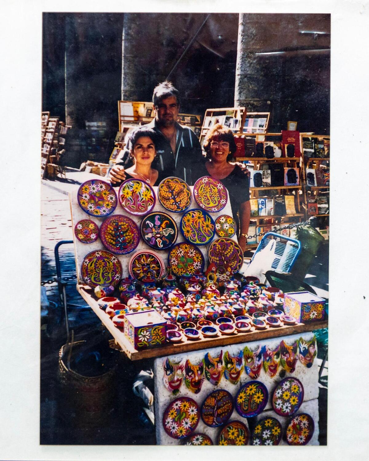 El artista Zaplaflora Jesús Torres, centro, su esposa María Travieso, izquierda, y una turista italiano, derecha, posan para una foto en la plaza de la Catedral de La Habana en La Habana, Cuba, en la década de 1990 cuando Cuba abrió el país a turismo. Torres vendió su primera obra de arte aquí ganando dos dólares el primer día.