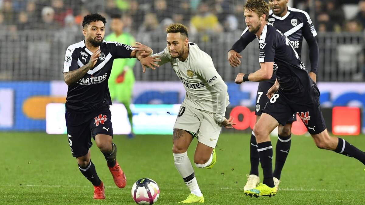 El delantero del Paris Saint-Germain Neymar (centro) avanza con la pelota ante la marca del brasileño Otavio, del Bordeaux (izq.), en un partido de la liga francesa el 2 de diciembre de 2018.