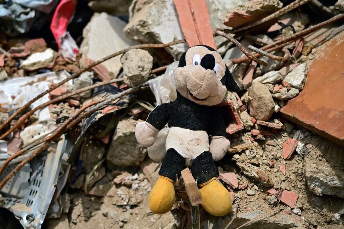 This image shows a plush Mickey Mouse amid rubble in the site of a collapsed building in Caraballeda, state of La Guaira, Venezuela, on July 10, 2026, following the June 24 twin earthquakes. The death toll from the powerful double earthquake has risen to at least 3,889, whilst the number of injured remains at almost 17,000, and nearly 18,000 people were left homeless according to the last official reports. (Photo by MARTIN BERNETTI / AFP via Getty Images)