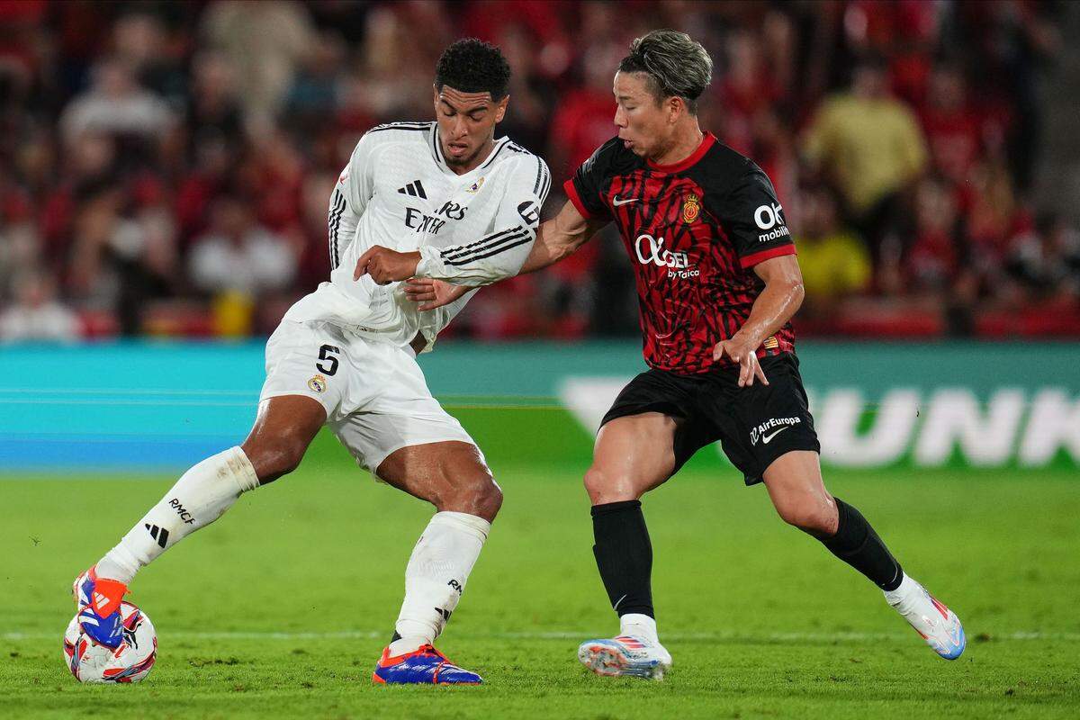 El mediocampista del Real Madrid Jude Bellingham (izq.) lucha por el balón con Takuma Asano, de Mallorca, en el partido de la liga española celebrado el 18 de agosto de 2024 en Mallorca.