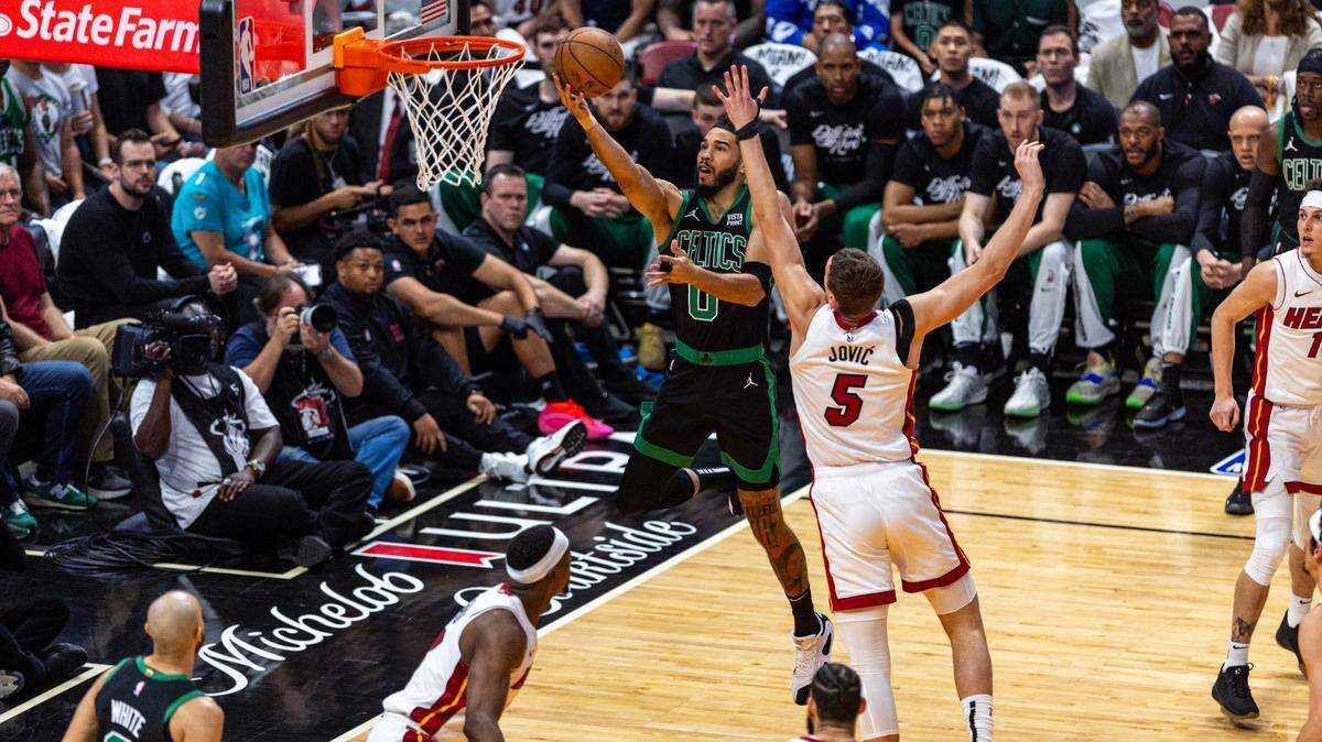 El delantero de los Boston Celtics, Jayson Tatum (0), tira en bandeja el balón mientras lo defiende el delantero del Miami Heat, Nikola Jovic (5), durante la primera mitad del tercer juego de una serie de playoffs de primera ronda de baloncesto de la NBA en el Kaseya Center de Miami, Florida, el sábado. 27 de abril de 2024.