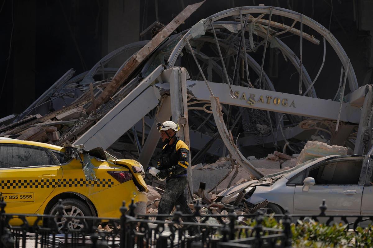 Un letrero del Hotel Saratoga de cinco estrellas cuelga entre los escombros después de una explosión mortal en La Habana Vieja, Cuba, el viernes 6 de mayo de 2022. (AP Foto/Ramón Espinosa)